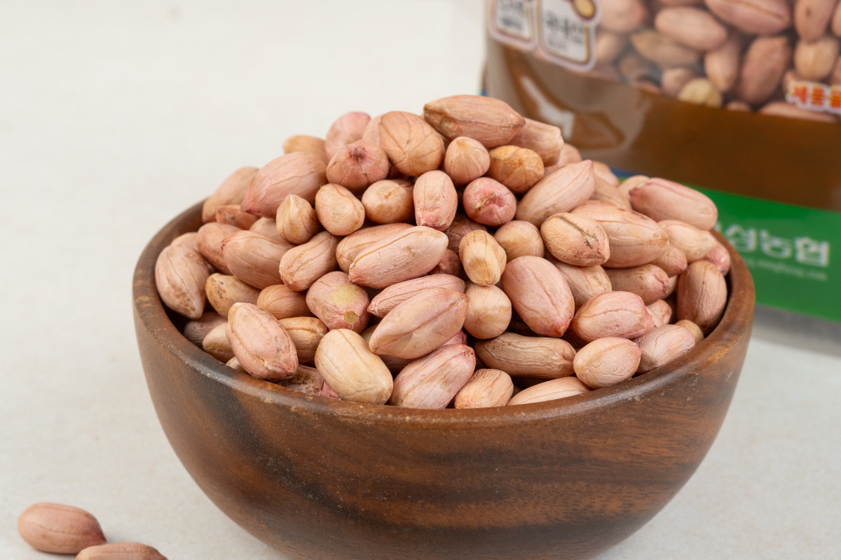 나무그릇에 가득 담긴 생알땅콩이 클로즈업되어, 국산땅콩의 고소한 색감과 땅콩조림이나 땅콩버터만들기에 적합한 상태를 표현함.