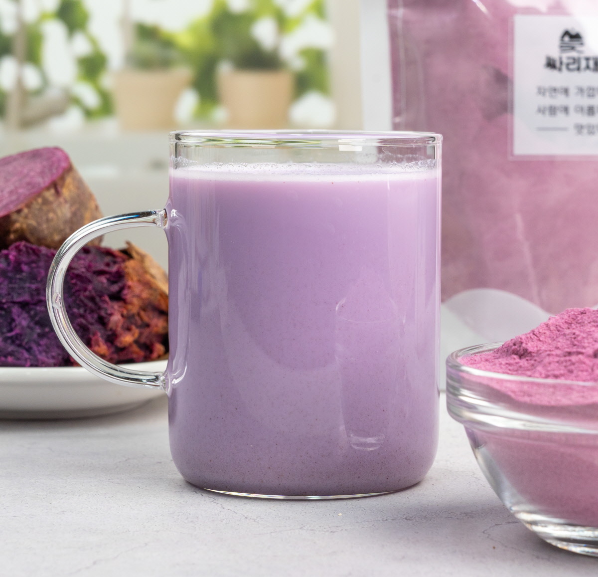 유리 머그잔에 자색고구마분말을 섞은 보라색 고구마라떼가 담겨 있고, 뒤에는 구운 보라고구마와 분말이 함께 연출된 차분한 홈카페 분위기