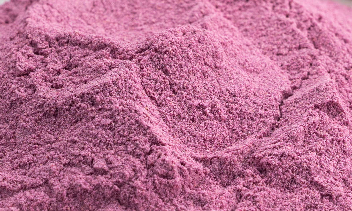 곱게 분쇄된 고운 질감의 보라색 고구마가루를 클로즈업한 장면으로, 부드럽고 균일한 분말 입자가 강조된 화면