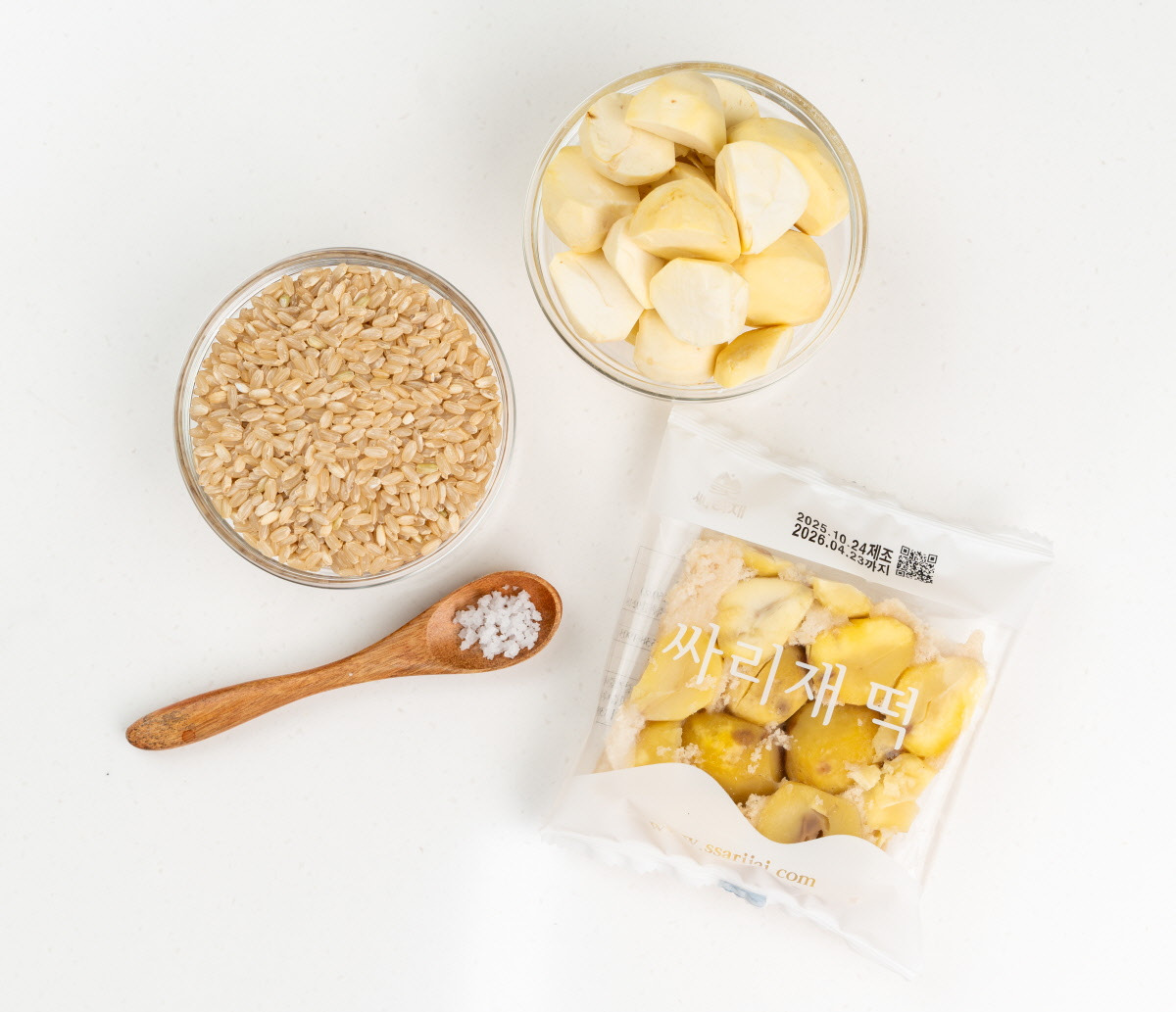 국산 유기농쌀과 생밤, 천일염을 나무숟가락과 함께 가지런히 배치한 구성으로, 건강한 재료로 만든 무설탕떡의 원료를 보여주는 연출