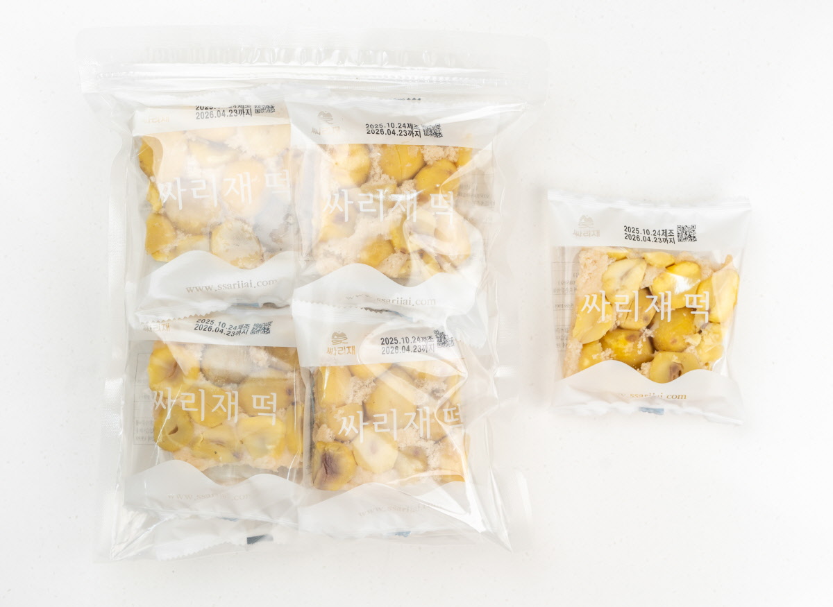 개별 포장된 밤설기 조각을 투명한 포장지에 담아 겹겹이 쌓아둔 모습으로, ‘싸리재떡’ 로고가 인쇄된 위생적인 소포장 구성