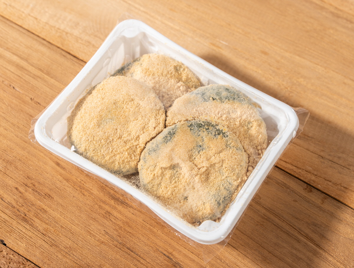 앙금쑥개떡 싸리재 개떡 4개를 흰색 용기에 담아 투명 필름으로 밀봉한 포장 모습으로 겉면에는 고운 콩고물이 넉넉히 덮여 있고 냉동 보관용 제품 구성이 한눈에 보임