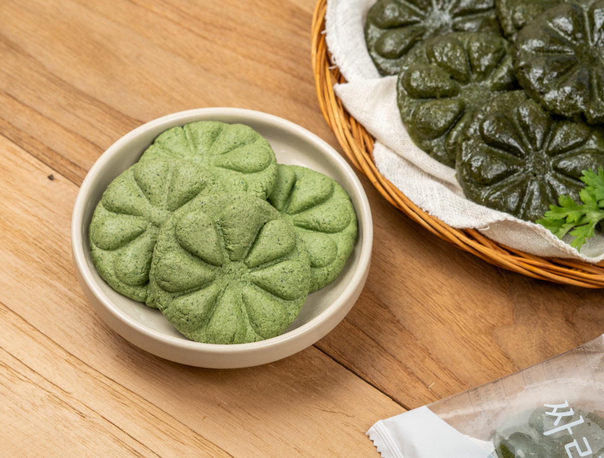 햇쑥 반죽으로 만드는 쫄깃한 쑥개떡 개별포장된 쑥개떡의 반죽 상태. 햇쑥을 넣은 고운 반죽이 산뜻한 연녹색으로 준비되어 있으며, 쫄깃한 냉동떡으로 완성 전 단계. 전통떡 만들기에 적합한 상태.