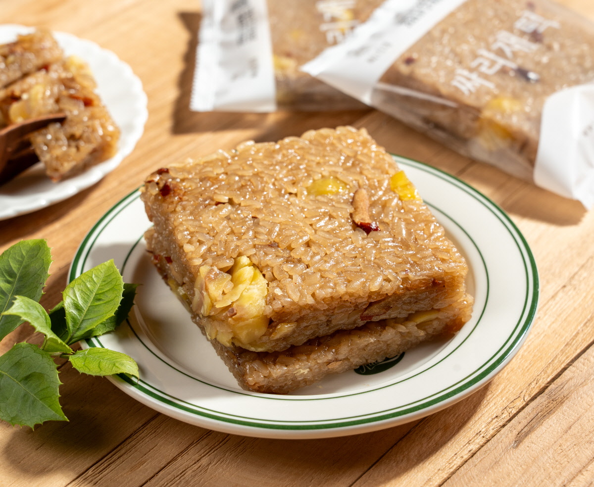 약밥 간편식으로 먹기 좋은 윤기 나는 찹쌀밥을 네모로 눌러 담고 밤 조각과 대추 조각이 박힌 두 장을 접시 위에 포개어 놓은 모습