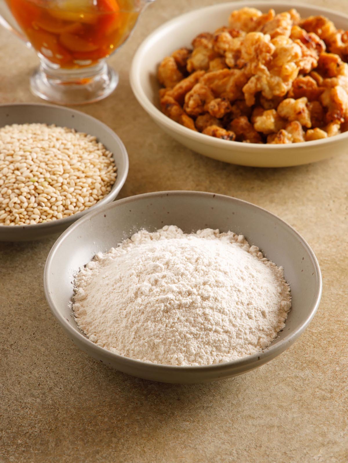 식탁위에 접시 3개가 있다. 유기농 현미찹쌀, 쌀가루, 탕수육 요리가 각각 담겨져 있다.