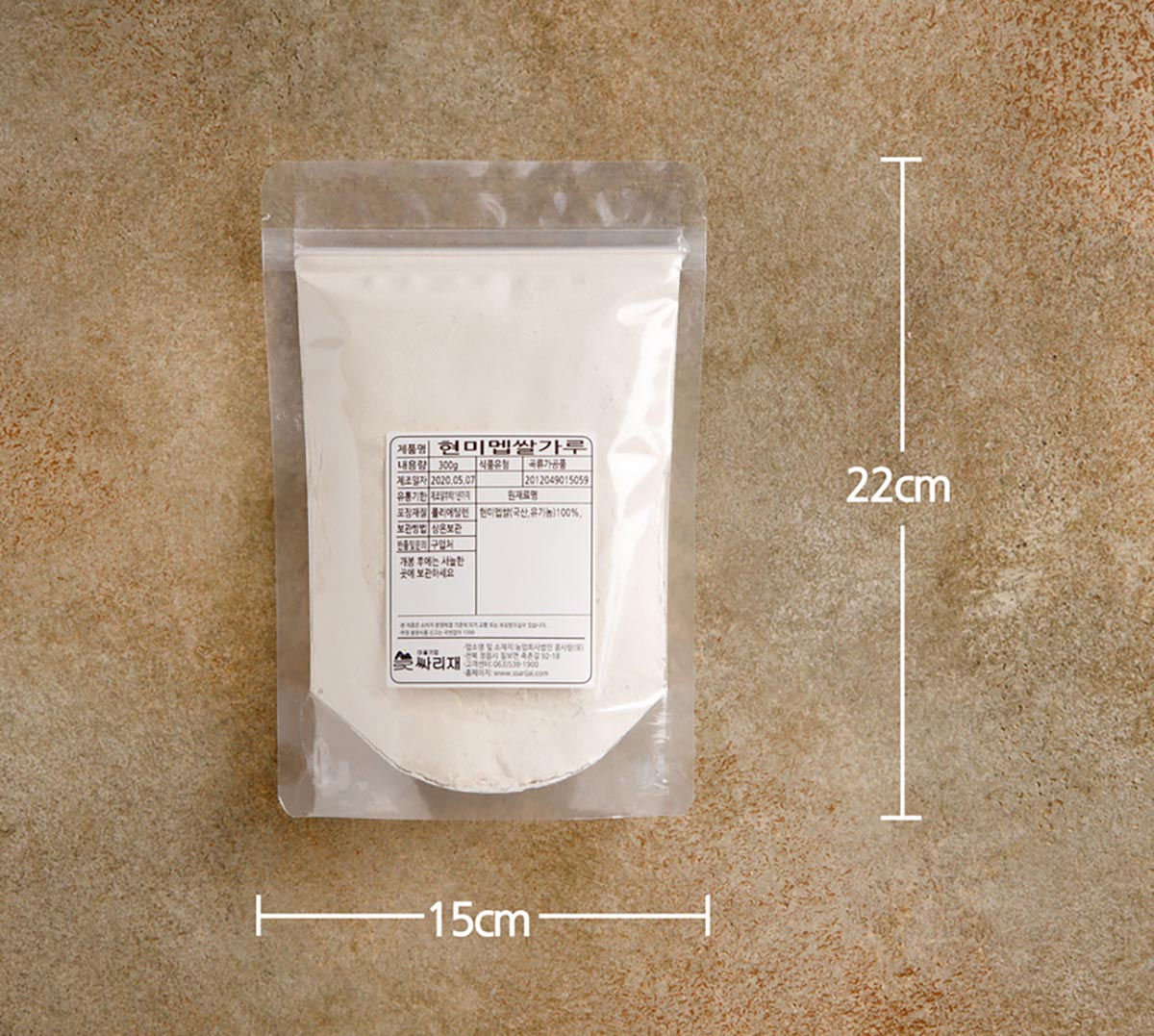 투명한 지퍼 포장지에 하얀 쌀가루를 담아 포장한 제품을 테이블에 놓은 모습.