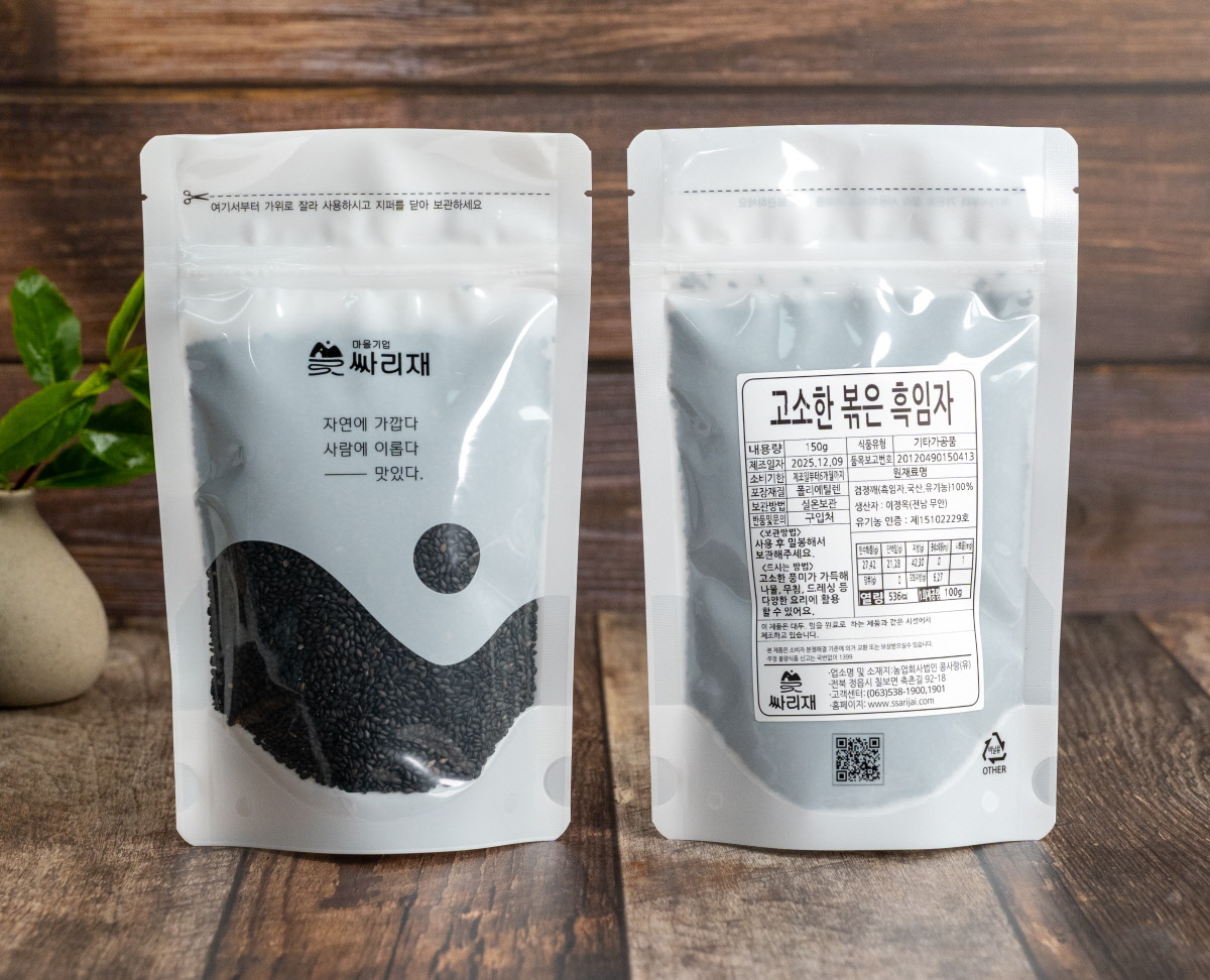 국내산검정깨로 만든 고소한흑임자 제품 포장이 앞뒤로 세워져 있으며, 앞면에는 ‘자연에 가깝다 사람에 이롭다 맛있다’, 뒷면에는 제품 정보가 정갈하게 적혀 있는 모습을 담은 장면.