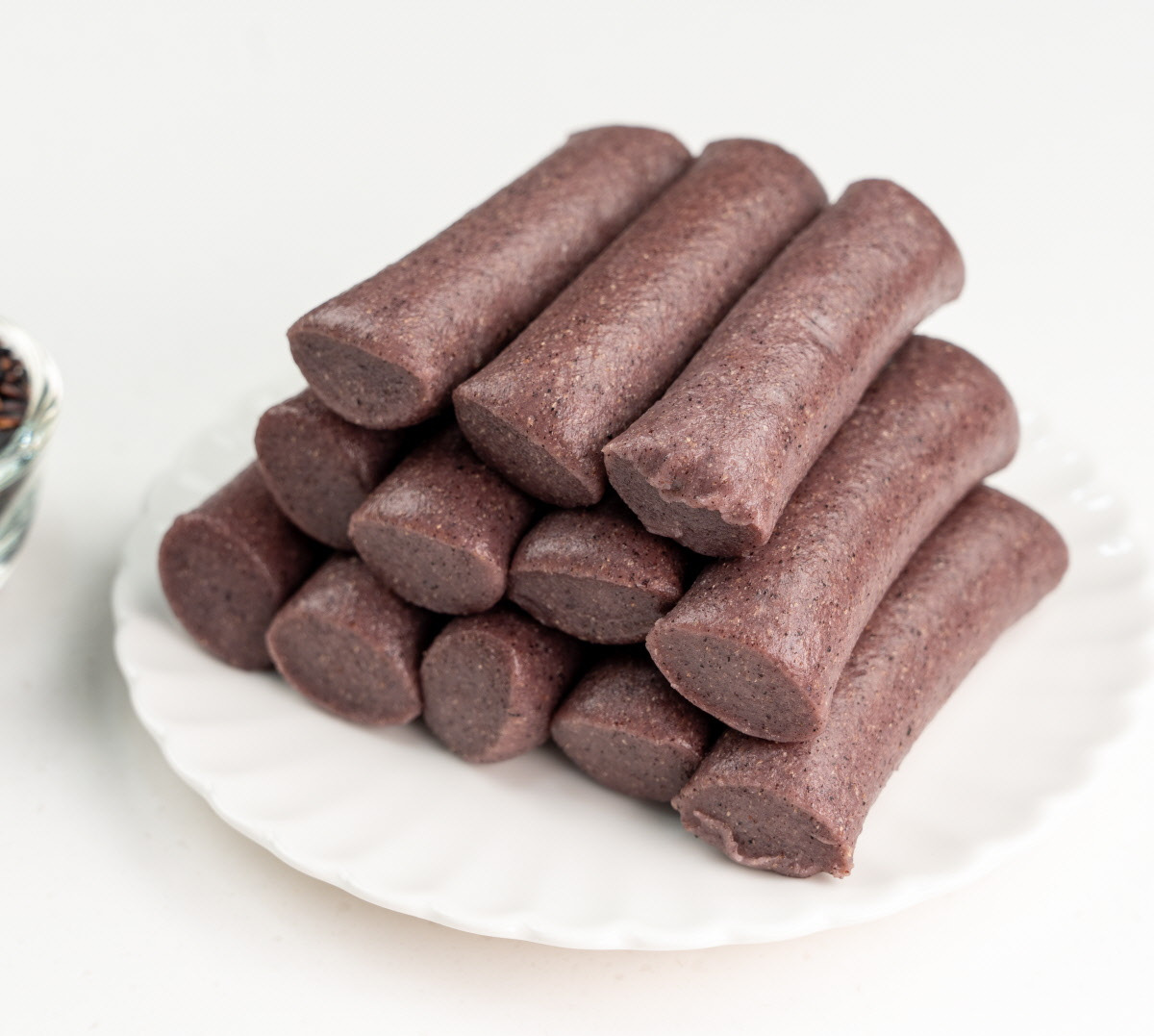 유기농 현미, 흑미, 천일염을 나무숟가락과 유리볼에 담아 재료의 신선함을 강조한 장면으로, 건강간식용 무첨가 가래떡의 원재료를 보여준다.