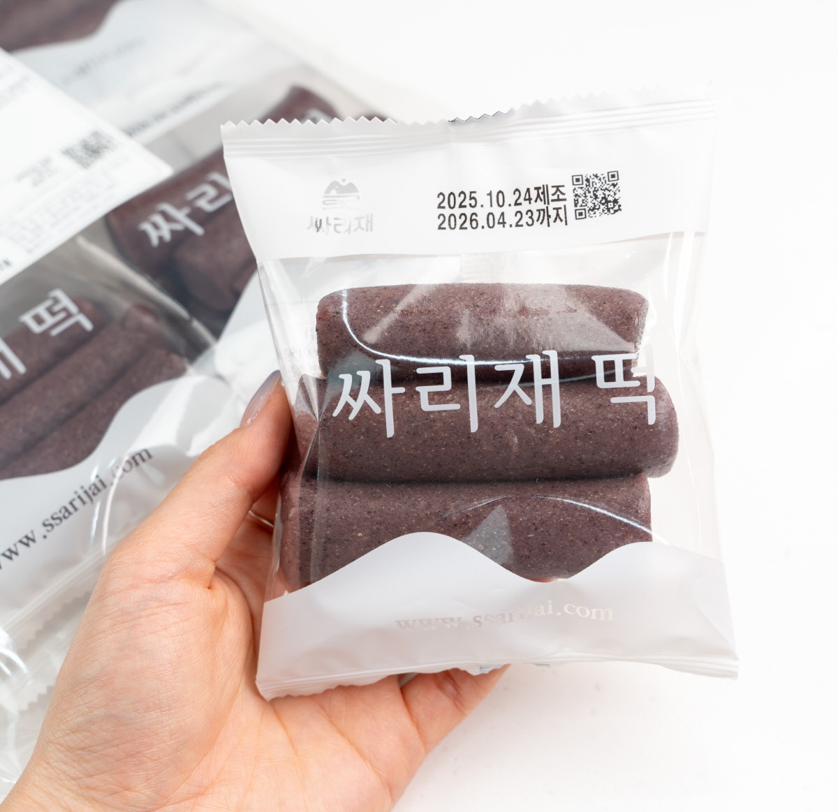 자연스러운 보랏빛이 감도는 흑미 가래떡을 가지런히 쌓아 올린 모습으로, 부드럽고 쫀득한 현미떡 질감을 강조하며 담백한 건강간식의 이미지를 전한다.