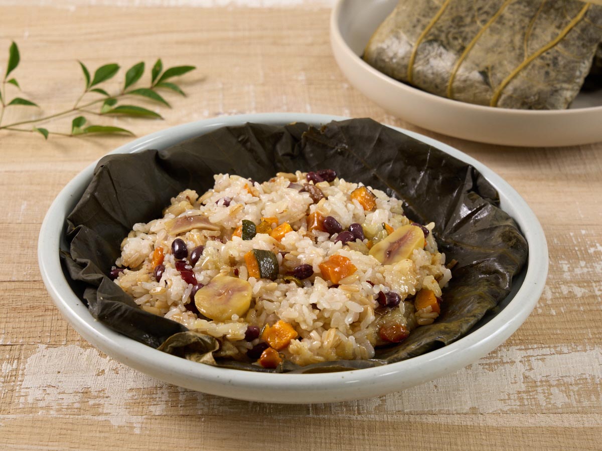 접시위에 연잎밥의 연잎을 벗겨 펼쳐놓은 모습, 찰밥과 단호박, 알밤이 섞인 연잎밥이 먹음직스럽다.