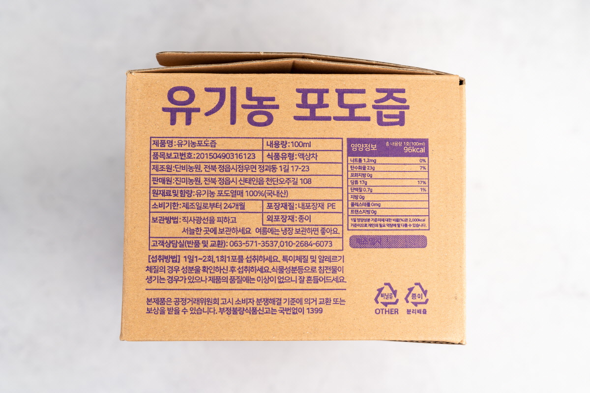 유기농포도즙 원재료·영양정보 안내면 박스 뒷면에 ‘유기농 포도즙’ 제품명, 내용량 100ml, 원재료명과 함량 ‘유기농 포도열매 100% 국내산’, 소비기한, 보관방법, 영양정보 1팩당 96kcal 등이 보라색 글씨로 자세히 인쇄되어 있다.
