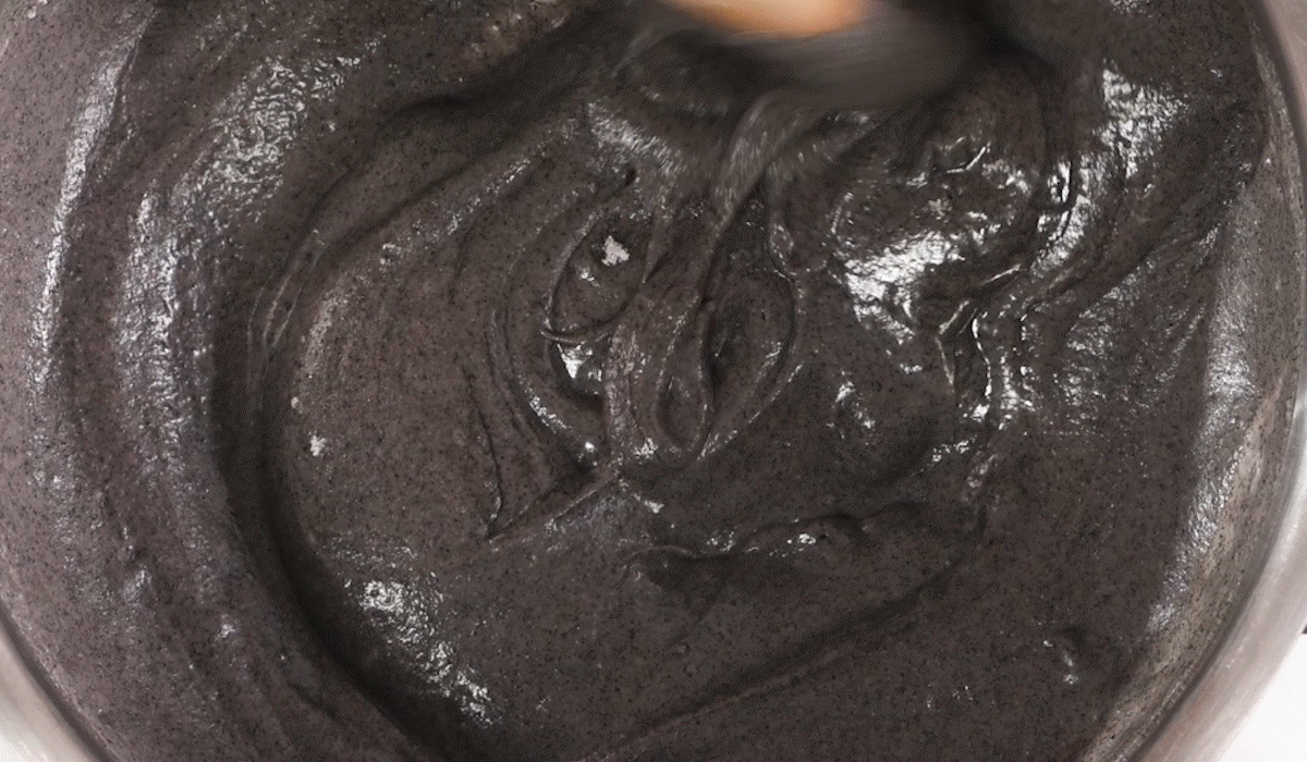 곱게 간 흑임자가루가 걸쭉하게 섞이며 윤기가 흐르는 흑임자죽이 만들어지는 장면으로, 국산흑임자 특유의 고소함과 질감을 보여주는 모습.