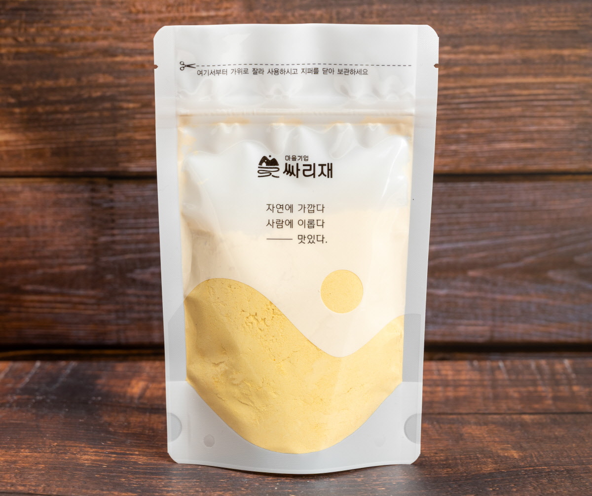 파우치에 담긴 곱고 밝은 유기농 단호박가루 단호박분말이 담긴 파우치가 서 있으며 포장 전면의 자연에 가깝다 사람에 이롭다 맛있다 문구가 보이고 호박분말 색감이 은은하게 드러남
