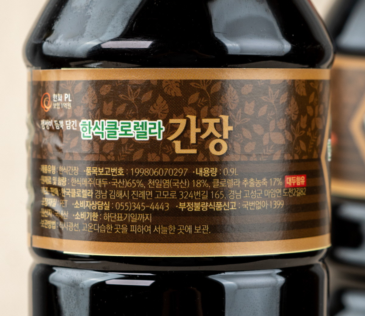 한식 클로렐라 간장의 뒷면 라벨이 클로즈업되어 있으며, 재료로는 국산콩과 국산 천일염, 클로렐라 추출물이 강조되어 있음