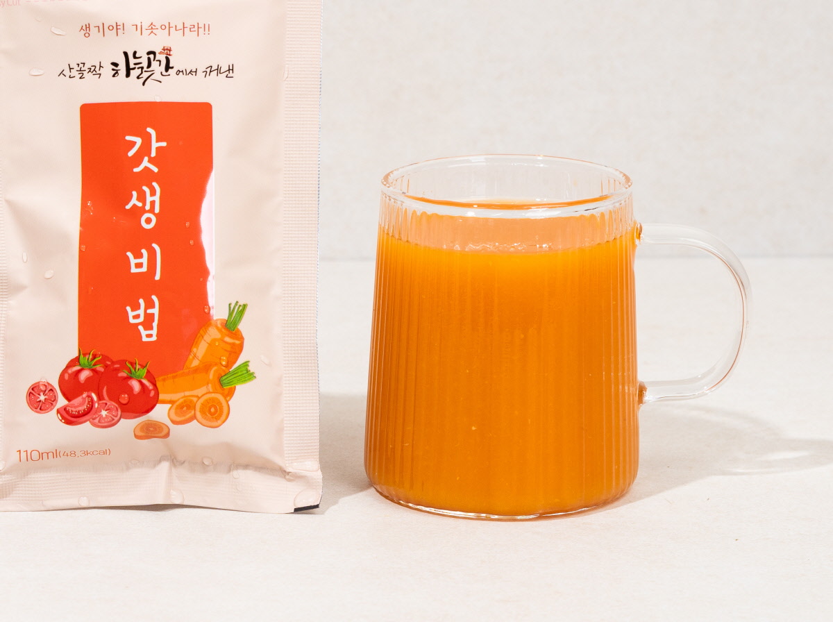 110ml 용량의 갓생비법 과채주스 패키지와 투명한 유리컵에 담긴 신선한 주스. 국산 사과, 토마토, 당근으로 만들어졌으며, 간편하게 즐길 수 있는 건강한 주스.