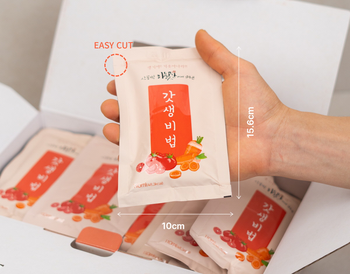 110ml 용량의 갓생비법 과채주스 개별 포장이 손에 들려 있는 모습. 한 손에 쏙 들어오는 크기로 간편하게 휴대할 수 있는 주스.