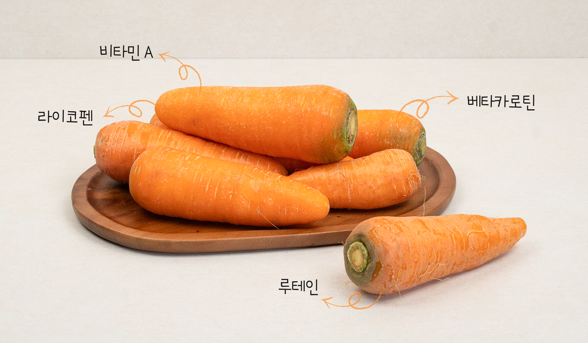 나무 접시에 놓인 국산 당근. 라이코펜, 루테인, 베타카로틴, 비타민 A가 함유된 영양 가득한 재료.