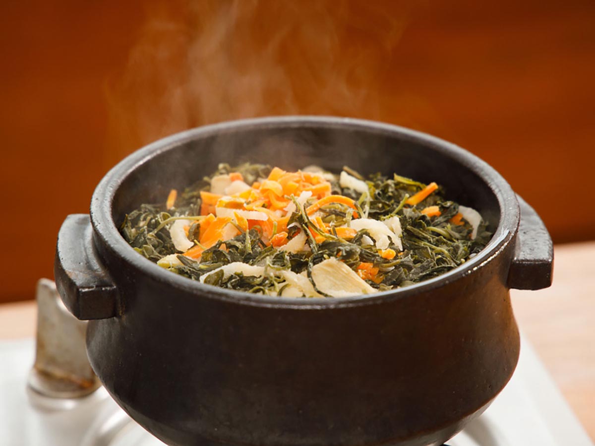 당근, 야채,인삼나물을 넣고 만든 비빔밥이 뚝빼기 안에서 모락모락 연기가 나고 있다. 
