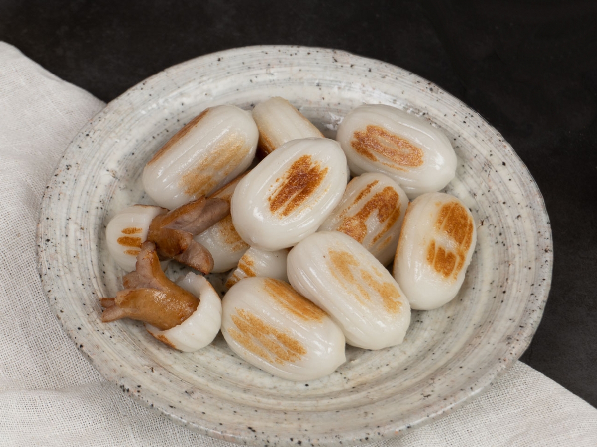 둥근 그릇에 노릇하게 구워진 꽃소떡이 가득 담겨 있습니다. 몇개의 다른 꽃소떡 알들은 쌀떡 부분을 삼분의 일정도 걷어낸 후, 그 안에 있던 소시지를 여러 가닥으로 갈라 문어발 모양을 만들었습니다.