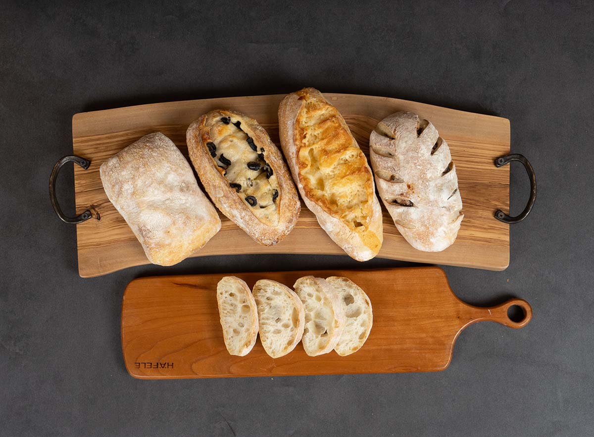 네니아가 만든 빵 4가지, 치아바타,무화과 사워도우, 올리브치즈 사워도우, 체다치즈 바게트를 도마위에 올려놓은 모습 